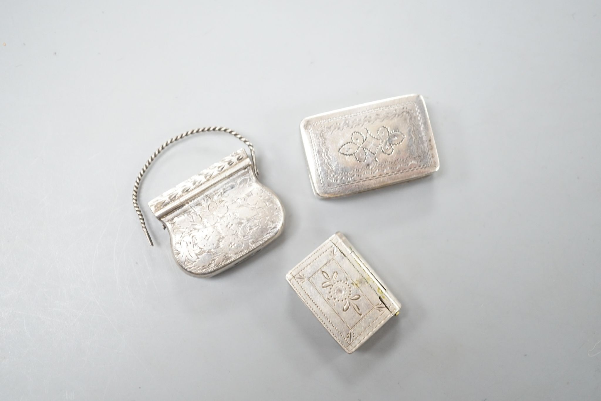 A George IV novelty silver vinaigrette, modelled as a handbag, Gervase Wheeler, Birmingham, 1832, 27mm(handle at one end detached), one other silver vinaigrette, Edward Smith, Birmingham, 1829 and a similar silver 'book'